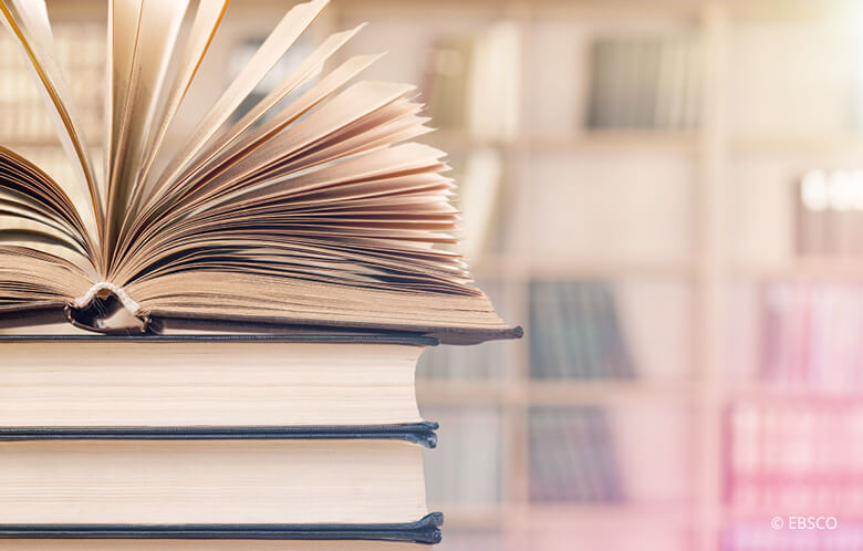 Image of stack of books with top one open and pages fanning out.