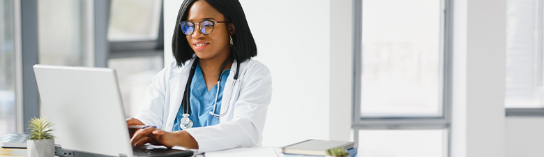 physician watching a video on laptop at a desk