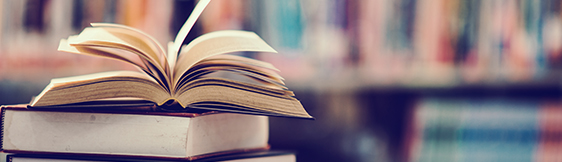 Open book on stack of book in library