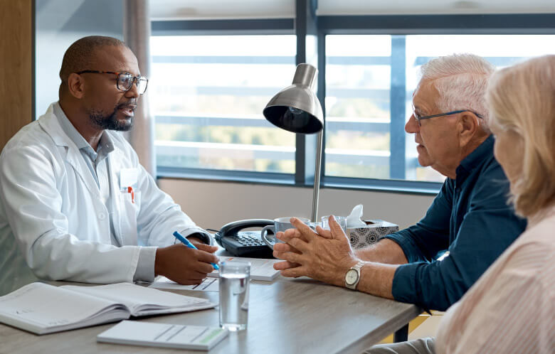 Doctor talking with a senior couple in office