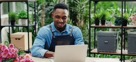 Flower shop owner on laptop. 