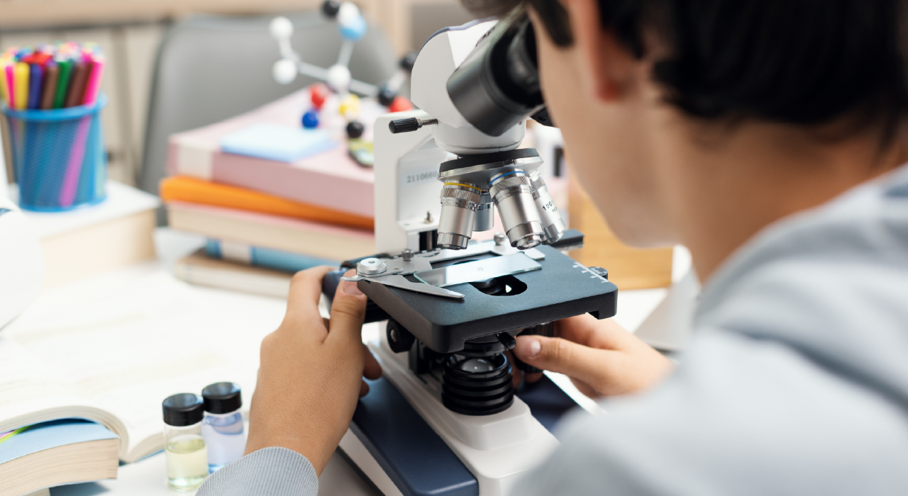 Young student using a microscope