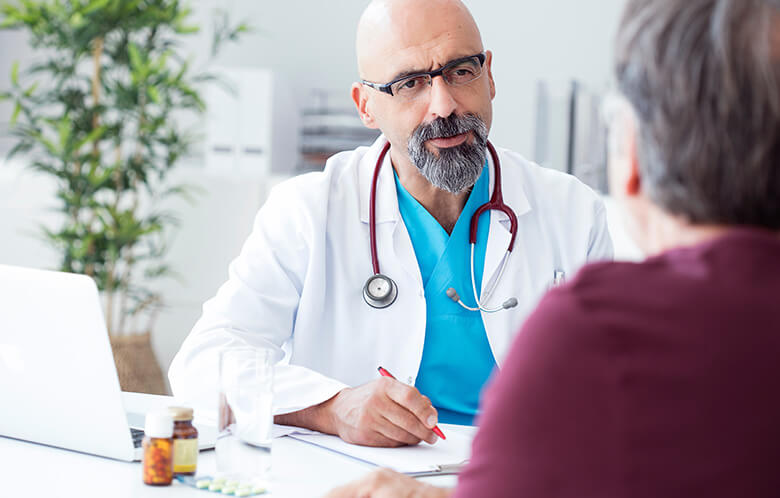 male doctor talking to patient while taking notes