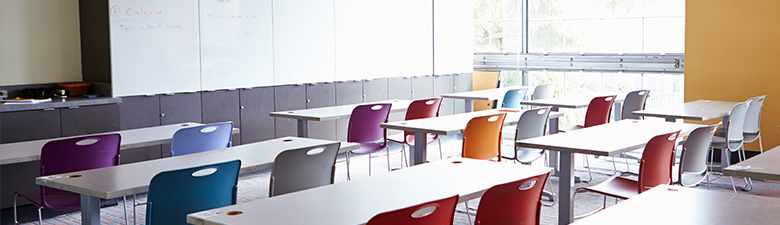 Classroom with a whiteboard and colorful chairs.