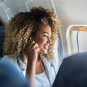 Woman with earbuds in on plane